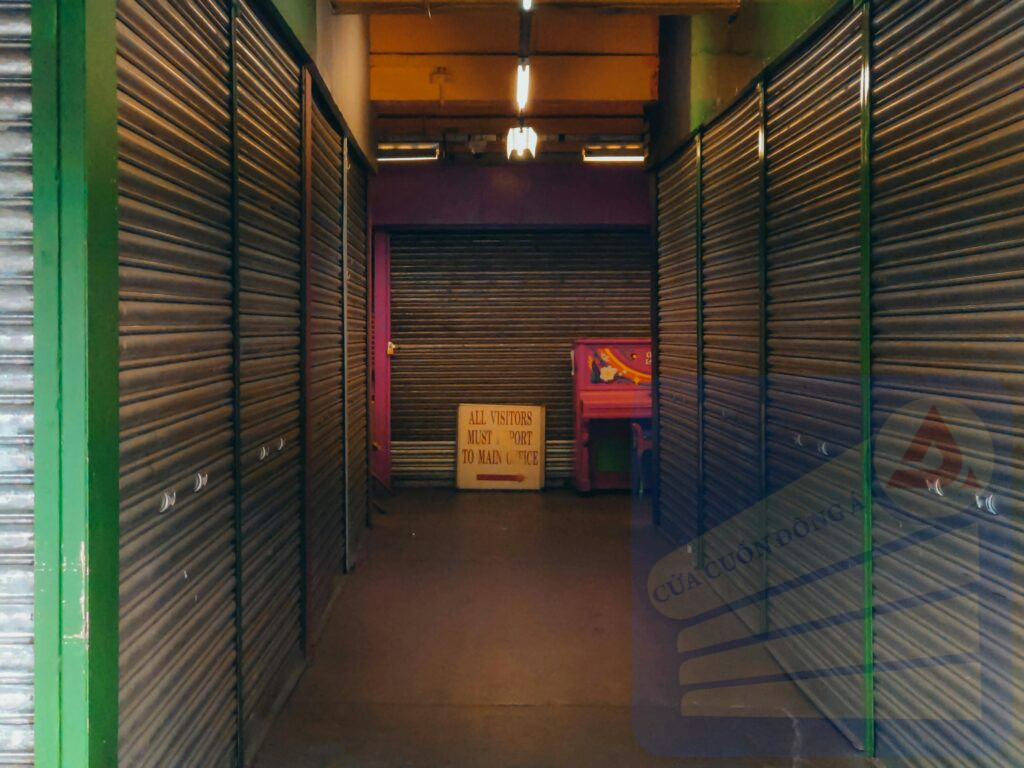 Dimly lit hallway with metallic shutter doors and a sign at the end, indicating a closed market.