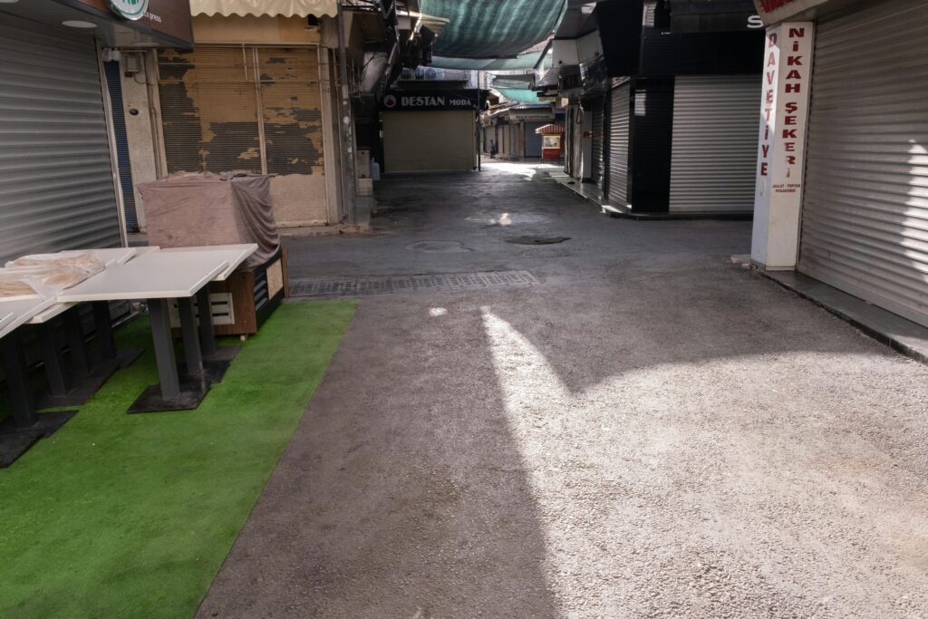 Deserted market street in İzmir with closed shops and roller doors.